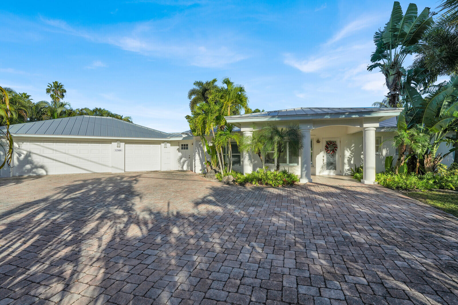 12980 Prosperity Farms Road Palm Beach Gardens, FL 33410 - Photo 4 of 55 a view of a house with a yard and potted plants
