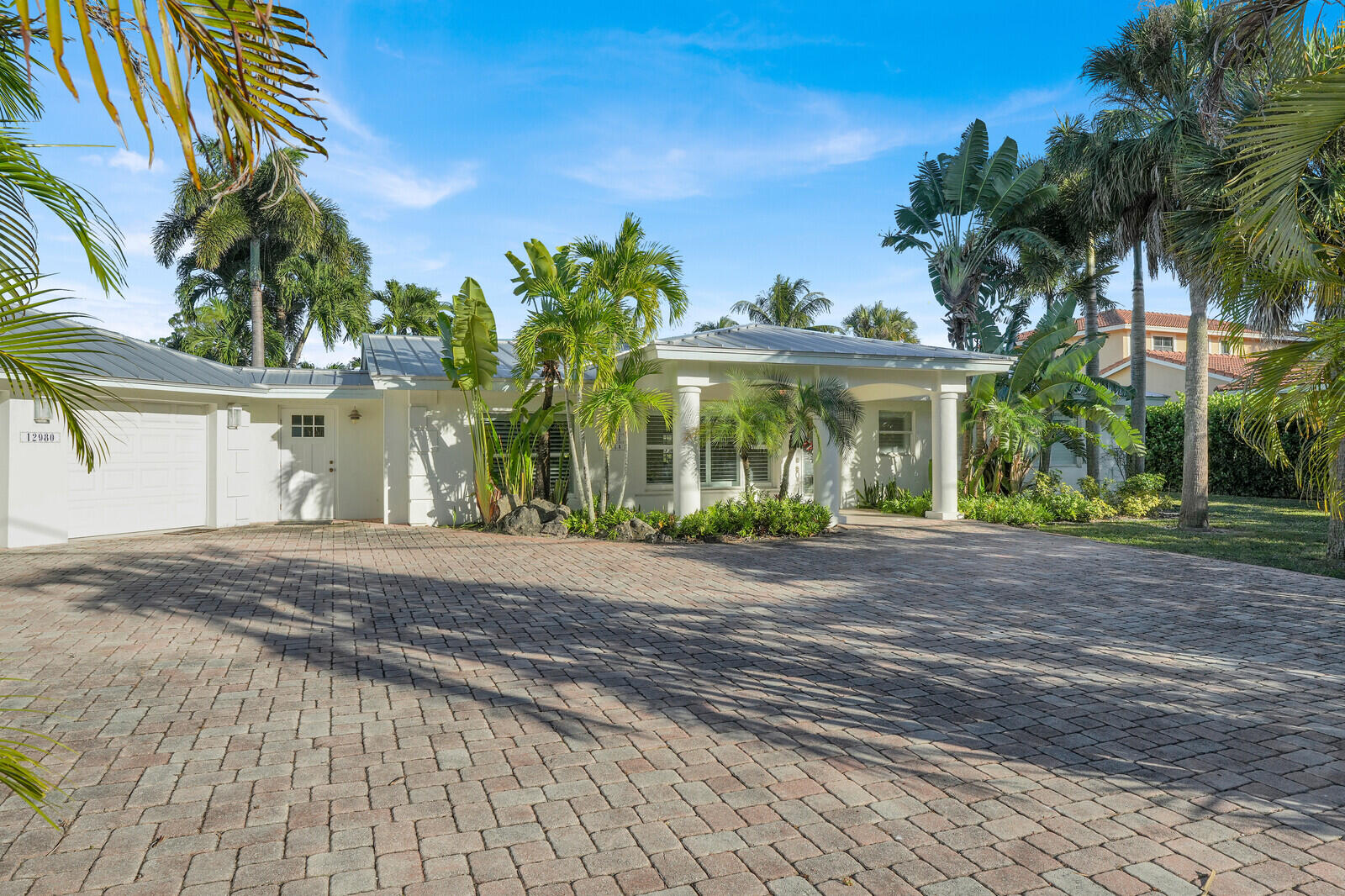 12980 Prosperity Farms Road Palm Beach Gardens, FL 33410 - Photo 6 of 55 a front view of a house with a yard and a garage