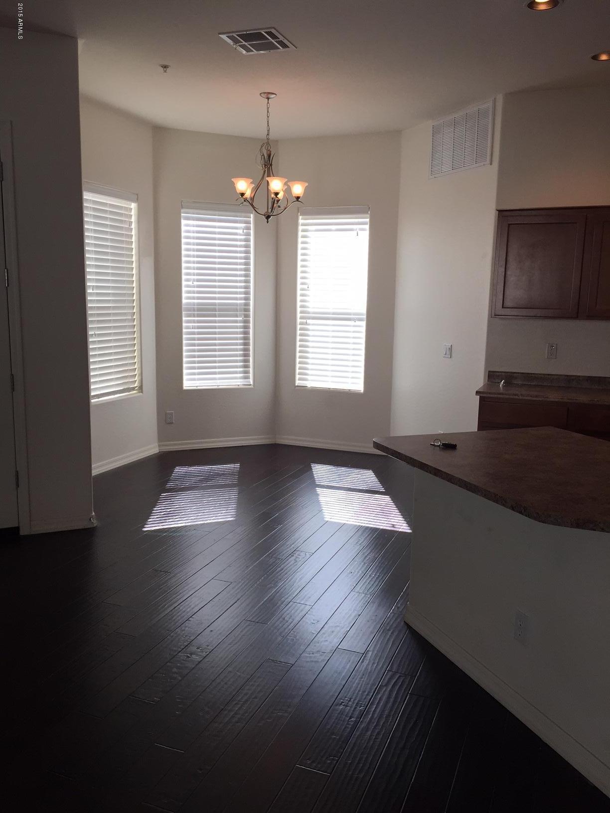 1502 East Dunlap Avenue, Unit 12 Phoenix, AZ 85020 - Photo 11 of 16 a view of an empty room with wooden floor and a window