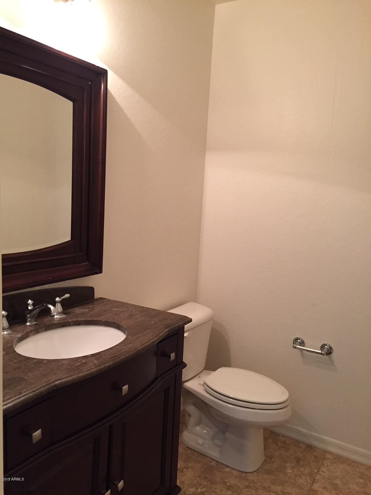 1502 East Dunlap Avenue, Unit 12 Phoenix, AZ 85020 - Photo 14 of 16 a bathroom with a granite countertop toilet a sink and mirror