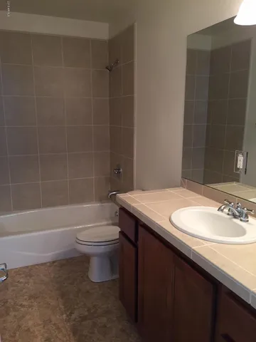 a bathroom with a sink a granite counter and a window