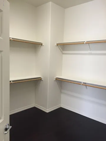 a view of an empty room with wooden floor and a fireplace
