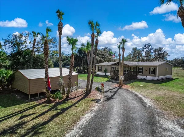 a view of a house with a yard and a patio