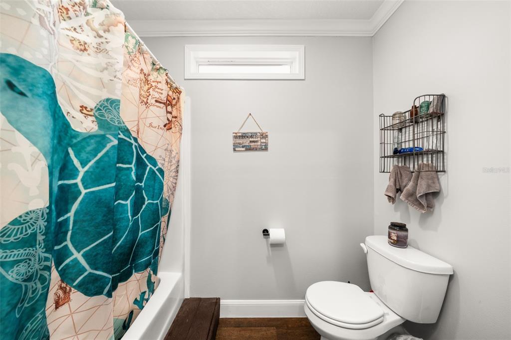 15405 Old Parker Island Road Lake Placid, FL 33852 - Photo 19 of 39 a white toilet sitting next to a shower curtain