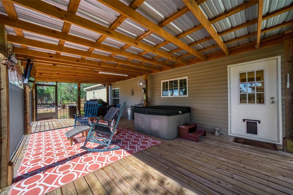 15405 Old Parker Island Road Lake Placid, FL 33852 - Photo 37 of 39 a outdoor space with the couches and dining table with wooden floor