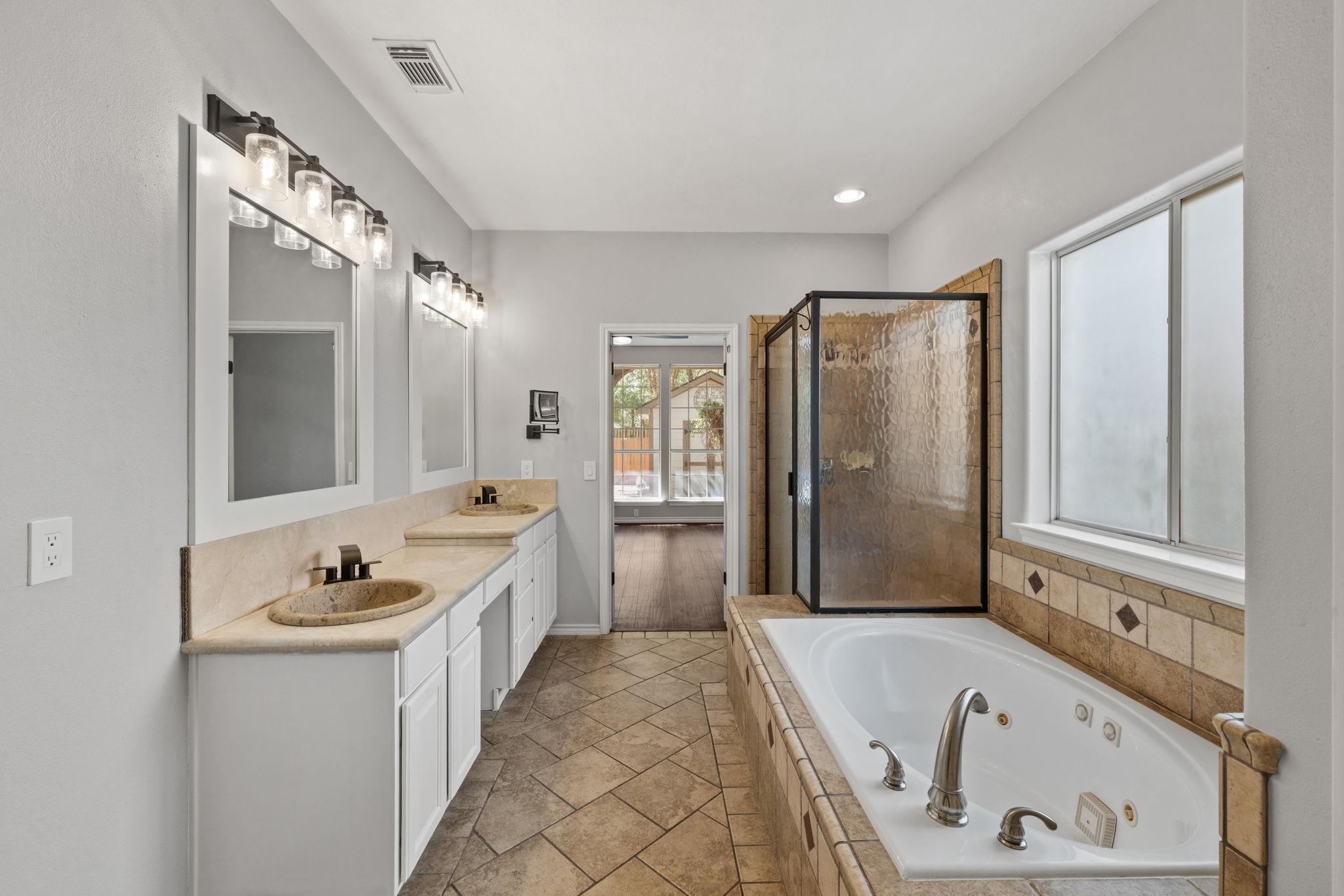 2211 Spring Hollow Path Round Rock, TX 78681 - Photo 24 of 36 A spacious layout highlights the tile flooring, dual-sink vanity, and separate soaking tub.