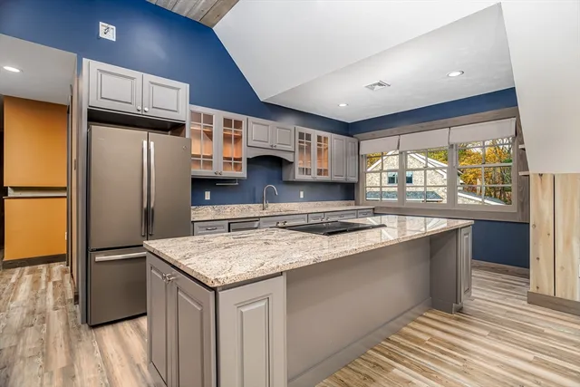 a kitchen with stainless steel appliances granite countertop a sink stove and refrigerator