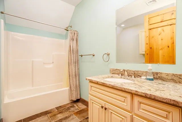 a bathroom with a granite countertop sink and a mirror