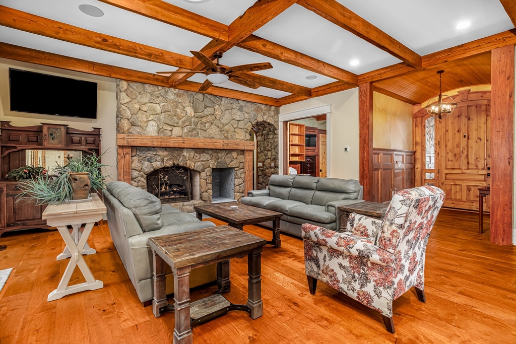 210 Indian Hill Road Groton, MA 01450 - Photo 9 of 42 a living room with furniture a flat screen tv and a fireplace
