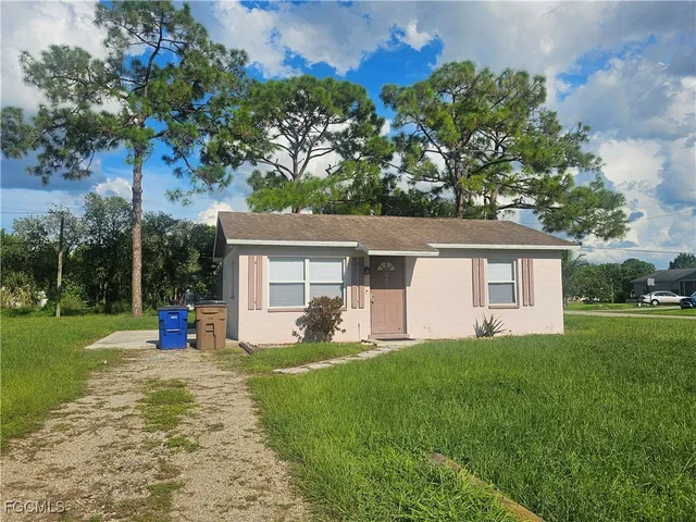 a view of a house with a yard and tree s