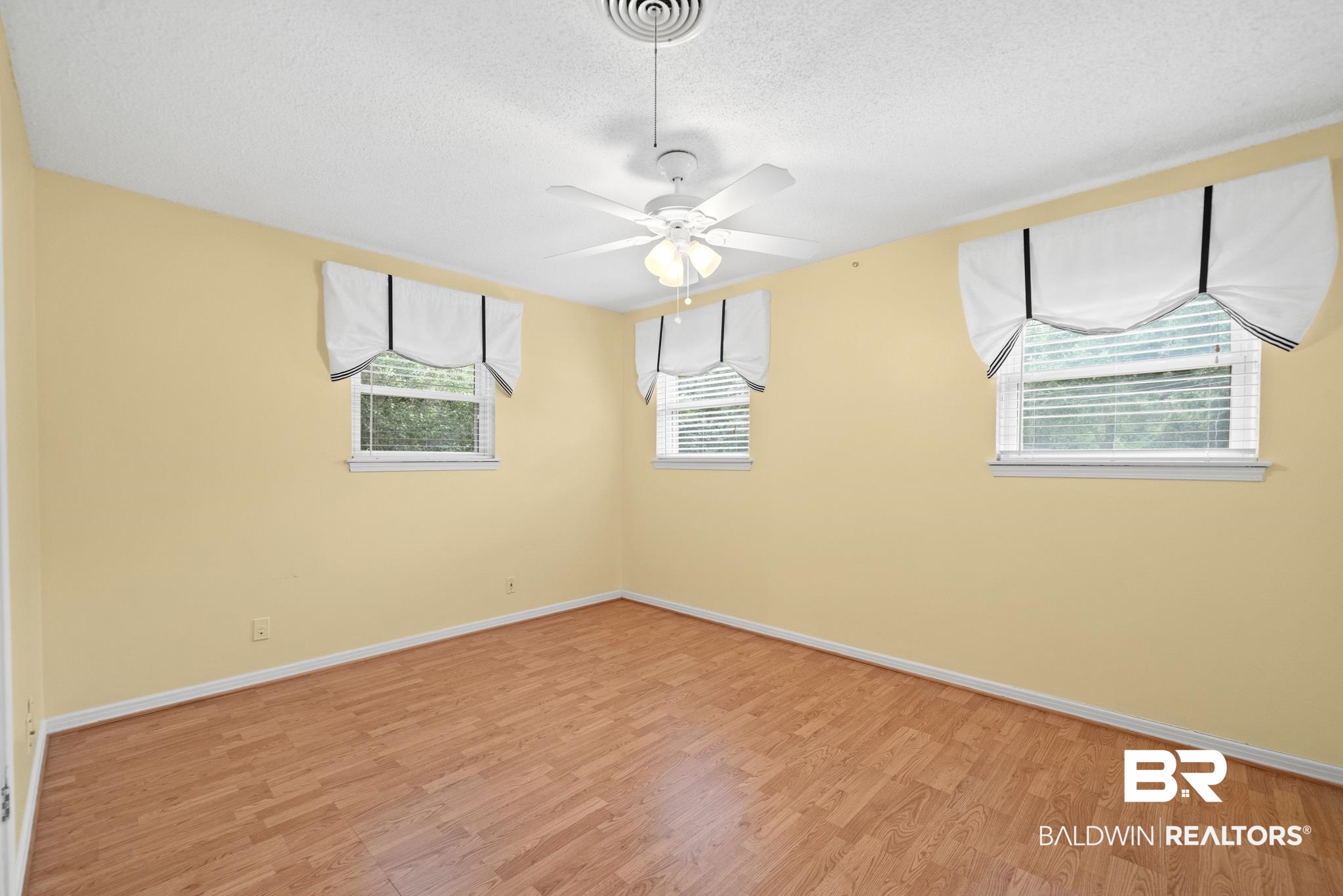 280 Thrift Street Mobile, AL 36609 - Photo 11 of 22 Spare room featuring light wood-type flooring, ceiling fan, and a healthy amount of sunlight