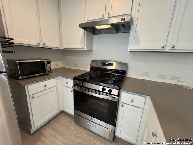 a kitchen with stainless steel appliances granite countertop a stove and a microwave