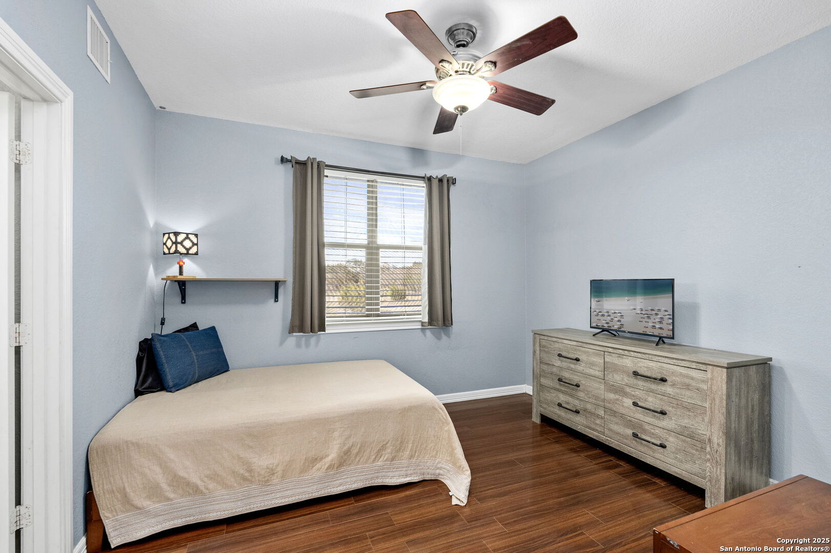 701 Kreutzberg Road Boerne, TX 78006 - Photo 24 of 43 a bedroom with a bed a dresser and a chandelier