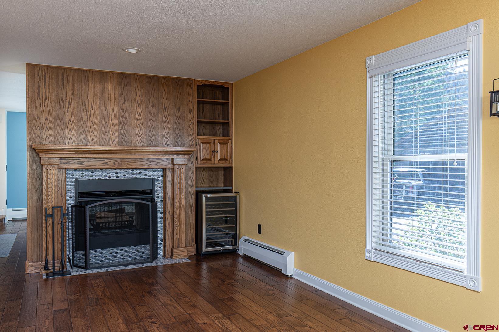 130 Hidden Treasure, Unit 1 Durango, CO 81301 - Photo 11 of 32 a view of an empty room with wooden floor fireplace and a window