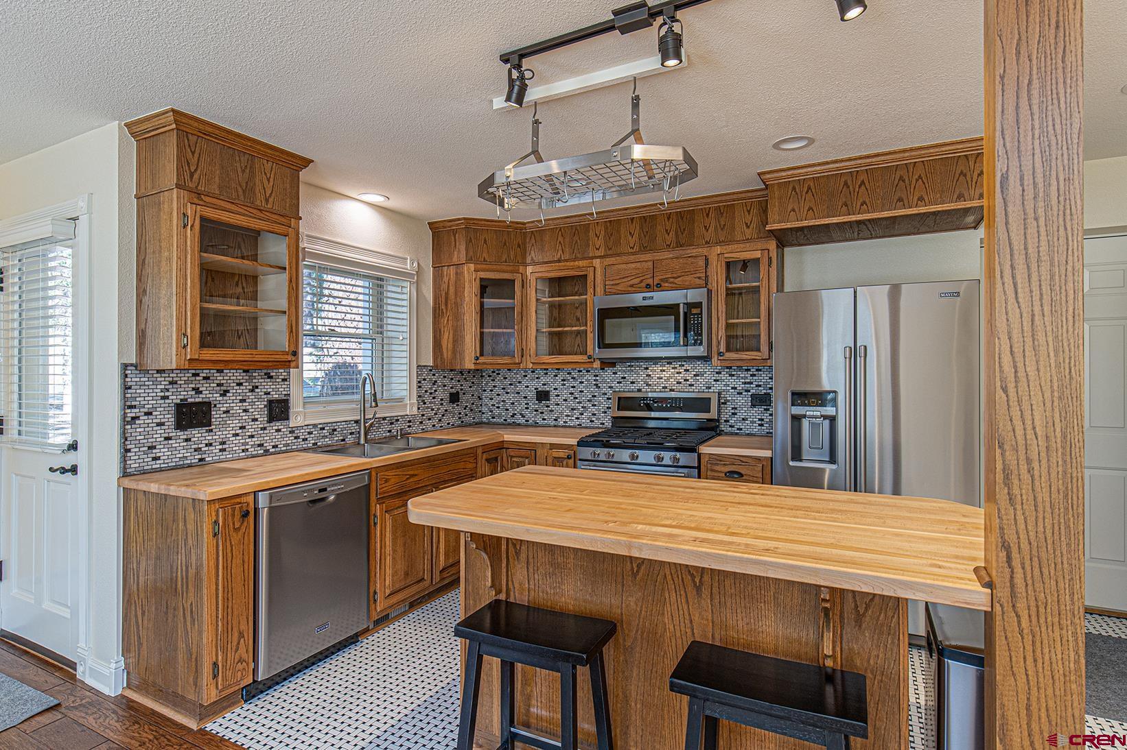 130 Hidden Treasure, Unit 1 Durango, CO 81301 - Photo 7 of 32 a kitchen with a table chairs sink and cabinets