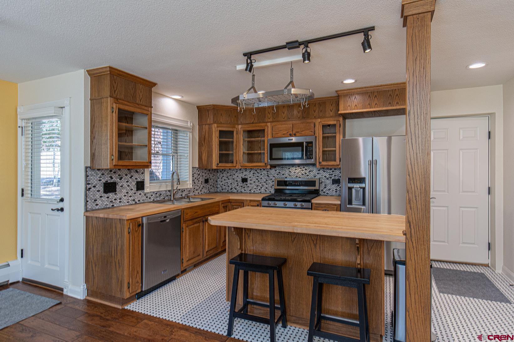 130 Hidden Treasure, Unit 1 Durango, CO 81301 - Photo 8 of 32 a kitchen with stainless steel appliances granite countertop a stove refrigerator sink and microwave
