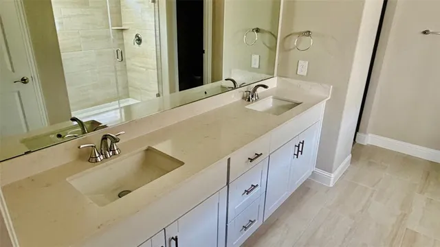 a bathroom with double vanity sink and mirror