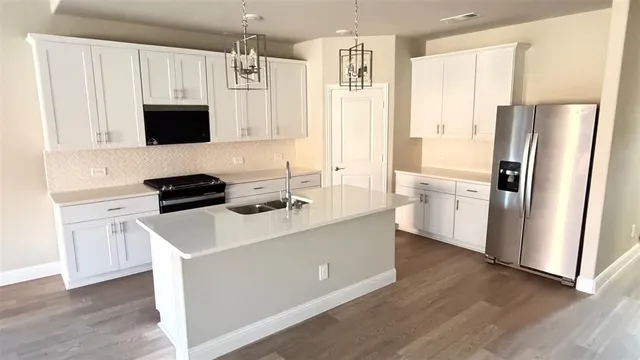 a kitchen with stainless steel appliances a refrigerator stove microwave and sink