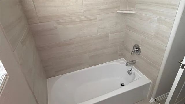 a bathroom with a white bath tub and a shower