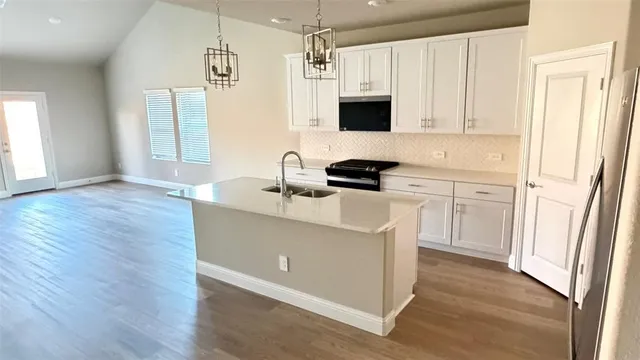 a kitchen with a sink a stove a microwave and cabinets