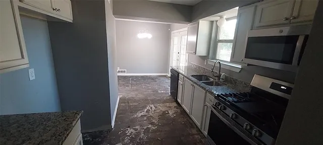 a kitchen with sink stove and cabinets
