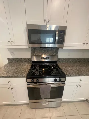 a stove top oven sitting inside of a kitchen