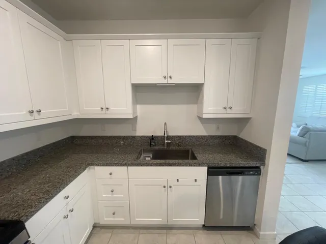 a kitchen with white cabinets and a sink