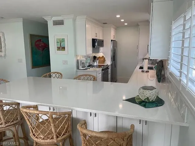 a kitchen with stainless steel appliances granite countertop a sink and a refrigerator