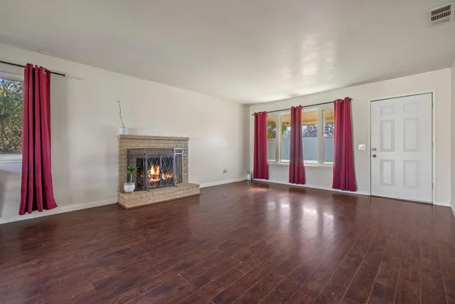 a view of a hallway to room with wooden floor