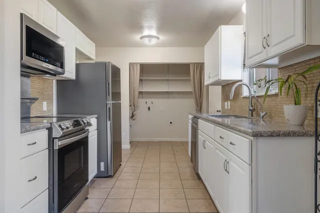 a kitchen with stainless steel appliances granite countertop a sink and cabinets