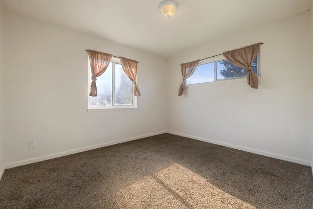 a view of a hallway to a livingroom and a dining room with furniture