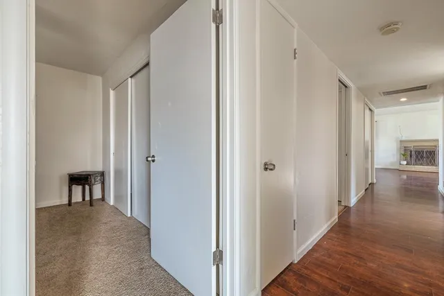 a view of a hallway to a livingroom and a dining room with furniture