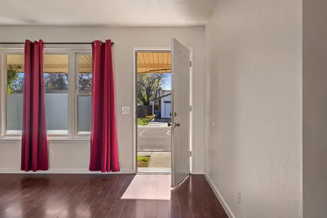 an empty room with wooden floor and fireplace