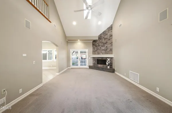 en empty room with windows and fireplace