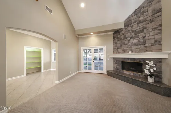 an empty room with fireplace and window