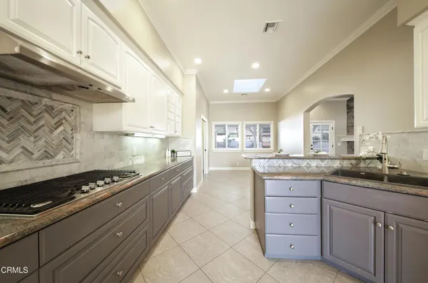 a large kitchen with granite countertop a stove and a sink