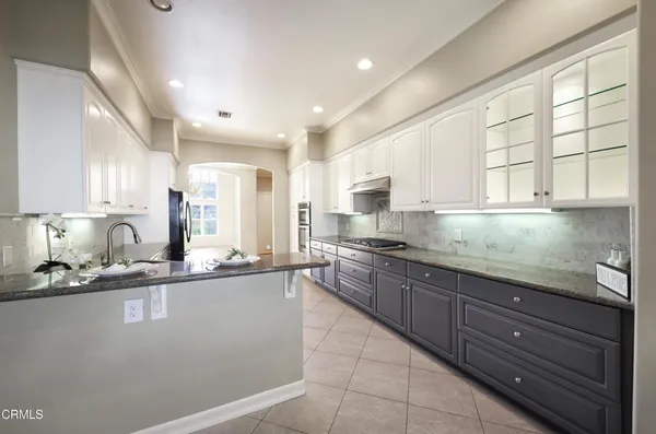 a large kitchen with stainless steel appliances granite countertop a sink and cabinets
