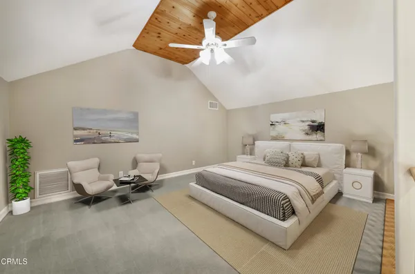 a bedroom with a bed a chair and potted plant on the dresser