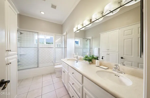 a spacious bathroom with a double vanity sink mirror and shower