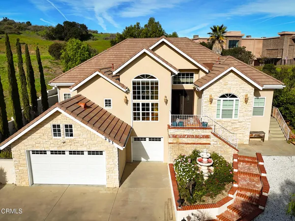 a view of a big house with wooden fence