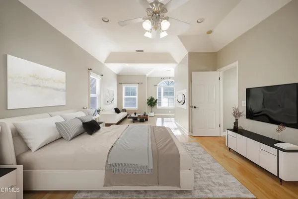 a spacious bedroom with a bed and a flat screen tv
