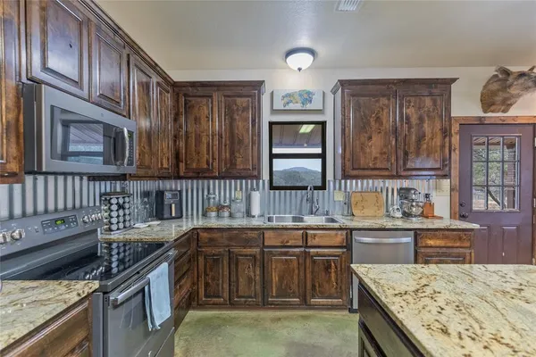 a kitchen with stainless steel appliances granite countertop a refrigerator and stove