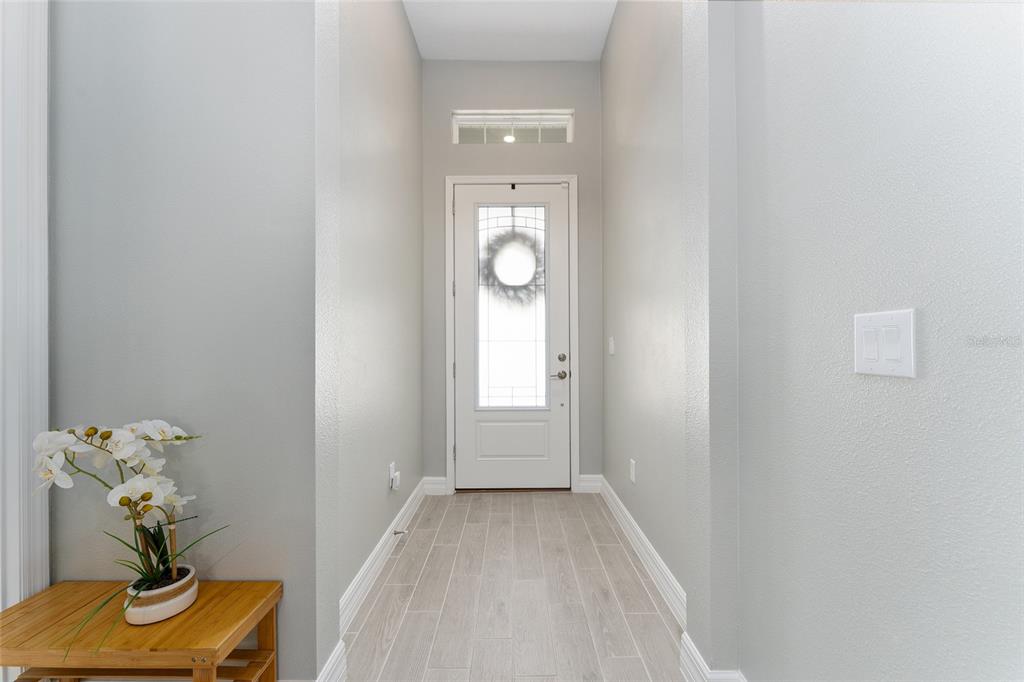1244 Southeast 42nd Road Ocala, FL 34480 - Photo 16 of 56 a view of a hallway with wooden floor and a potted plant