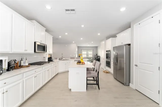 a kitchen with white cabinets and appliances