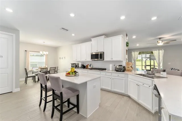 a dining room with stainless steel appliances a table and chairs