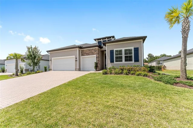 a front view of house with yard and trees in the background