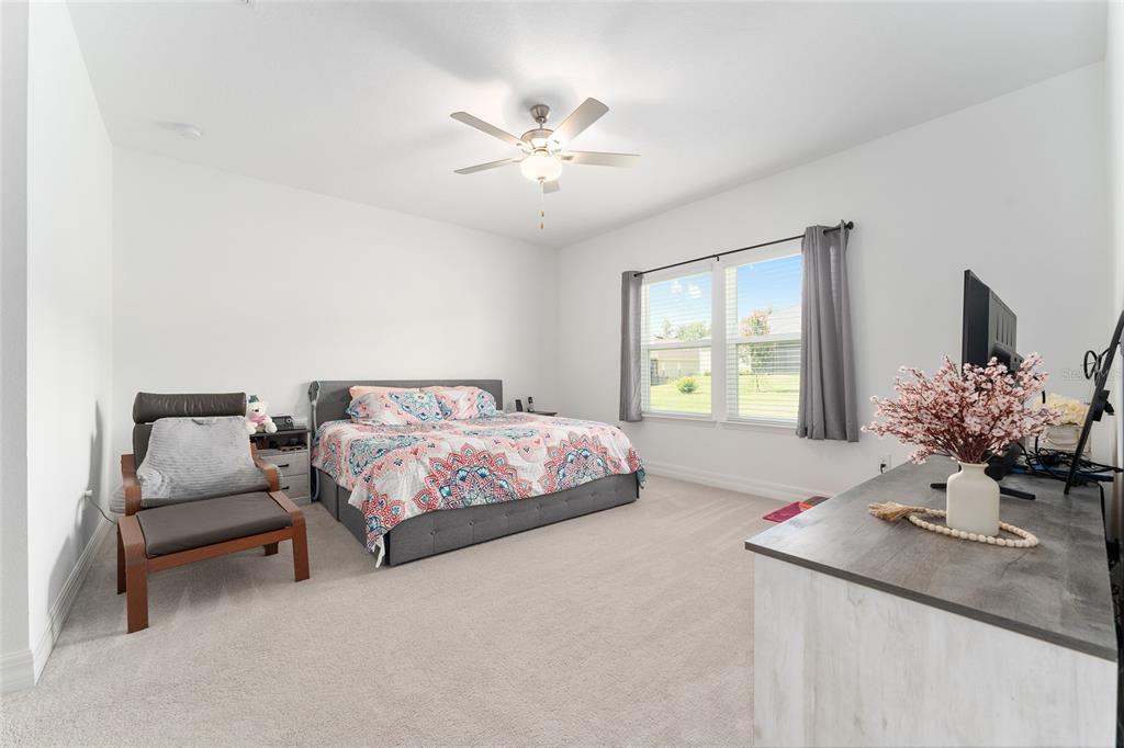 1244 Southeast 42nd Road Ocala, FL 34480 - Photo 49 of 56 a bedroom with a bed and a chandelier