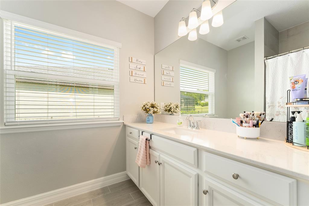 1244 Southeast 42nd Road Ocala, FL 34480 - Photo 51 of 56 a bathroom with a sink a large mirror and a window