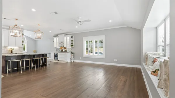 a view of hallway with window and wooden floor