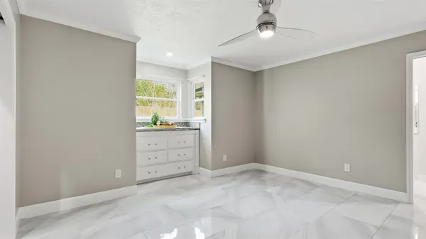 front view of a house with a yard and potted plants